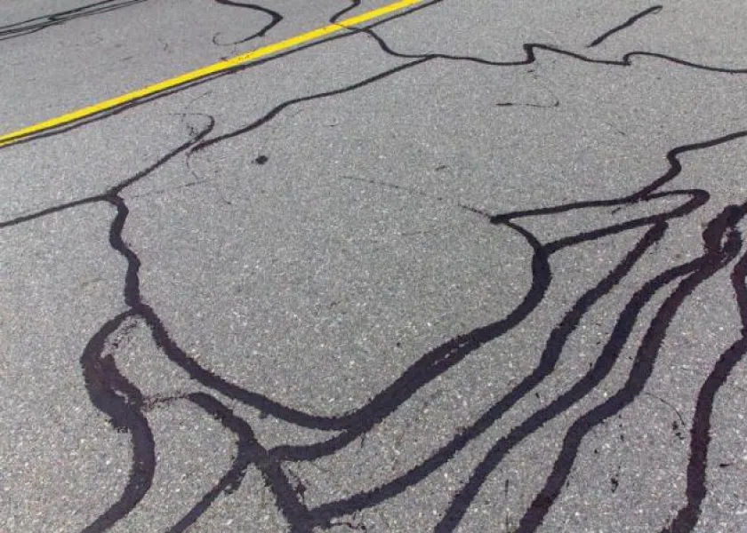 Cracked road lines filled with tar resemble the outline of the African continent.